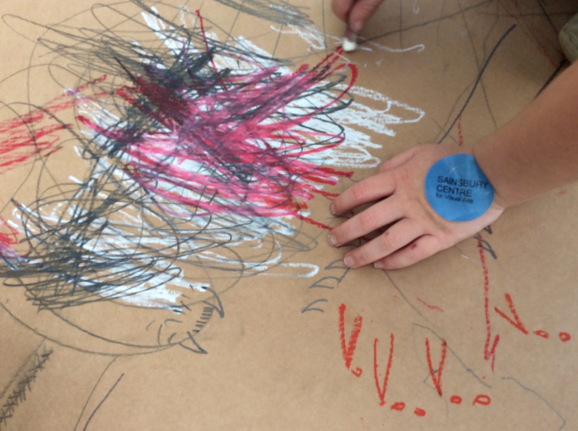 Child’s hand, blue sticker, cardboard