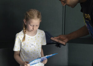 Young girl recording a piece of written work she has done